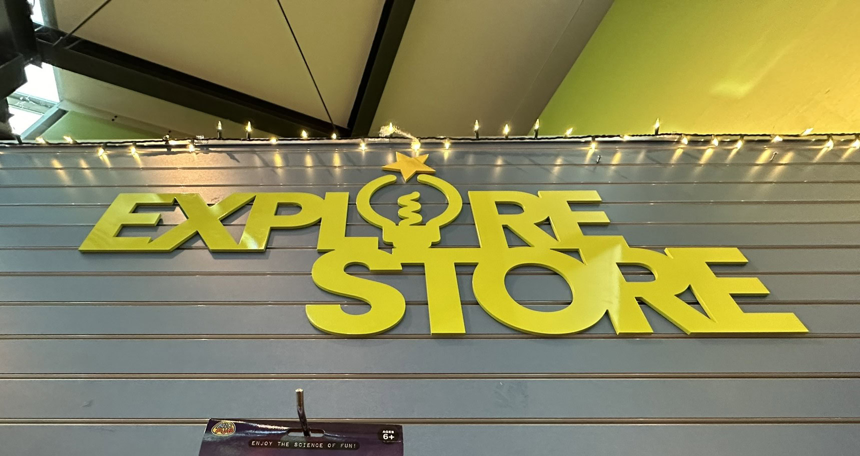Bright yellow Explore Store sign at Pronto Print Medford location.
