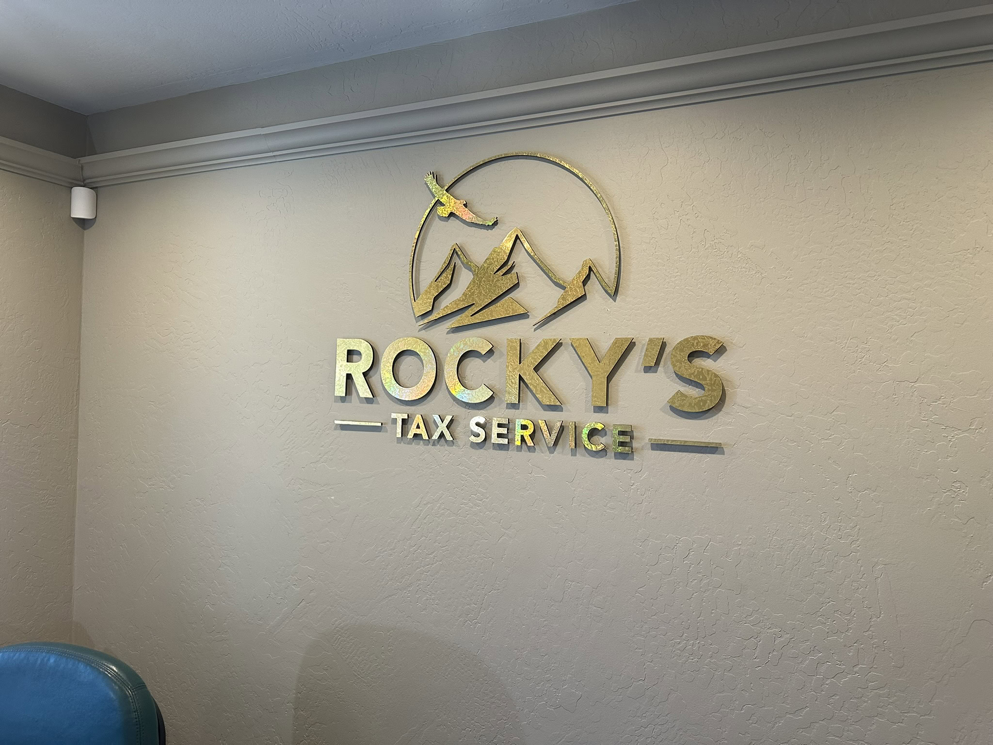 Sign of Rocky's Tax Service with mountain and eagle logo.