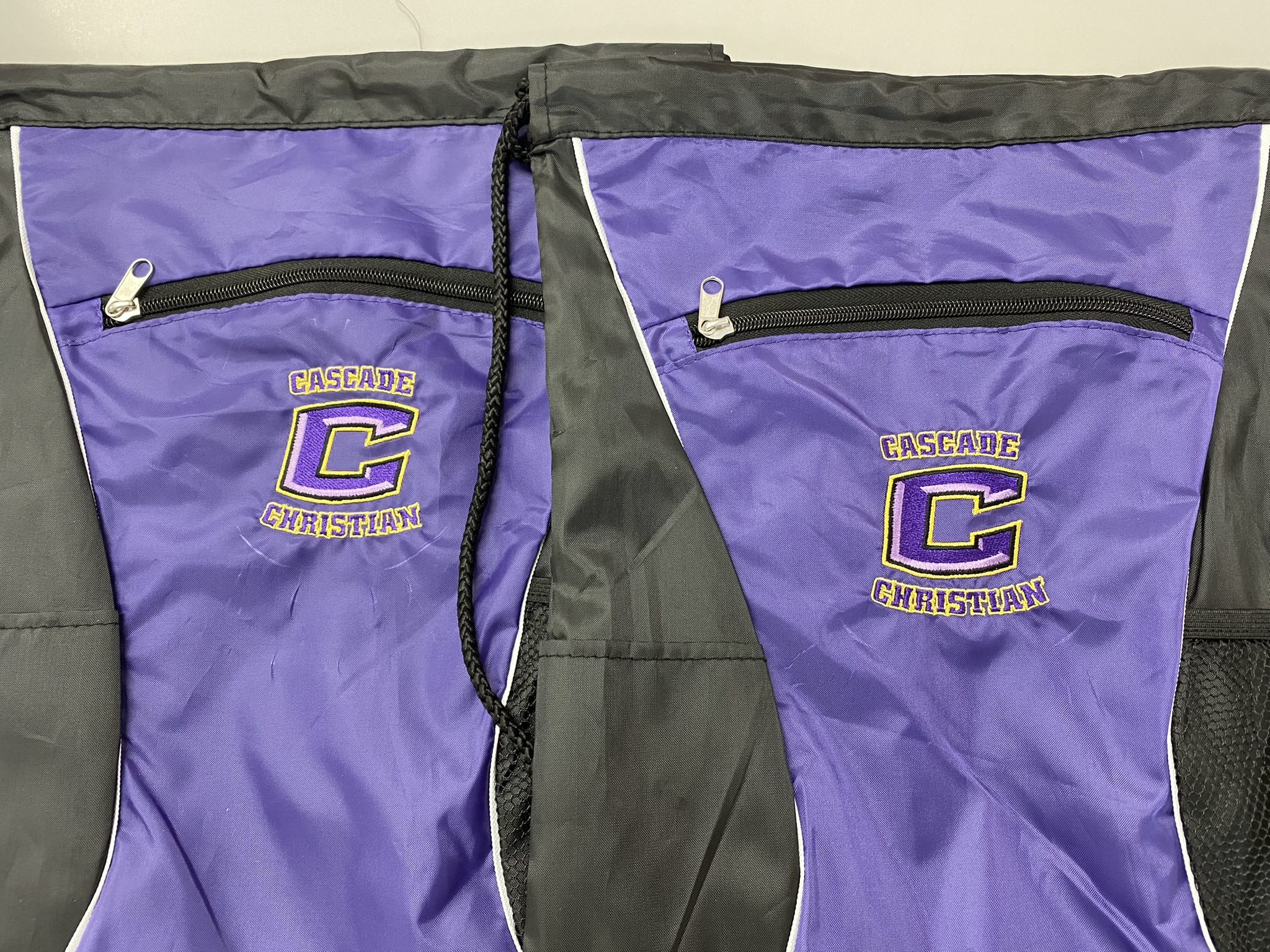 Purple Cascade Christian backpack with school logo and zippered pockets.
